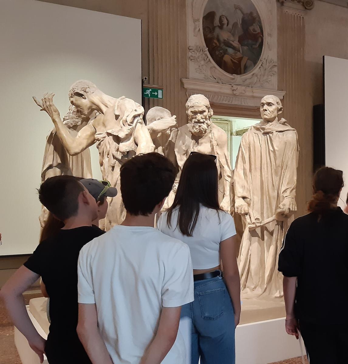 ragazzi di spalle davanti ad una scultura